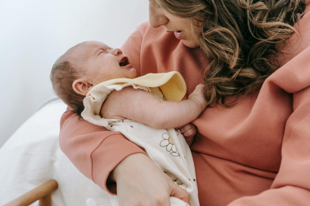 mom holding crying baby